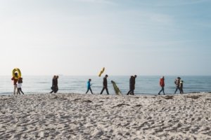 Familienshooting am Strand – Goldene Hochzeit mit Generationen in Rostock Familienshooting am Strand von Rostock: Drei Generationen spazieren gemeinsam entlang der Ostseeküste, mit Blick aufs Meer und goldenen Ballons zur Feier der goldenen Hochzeit.
