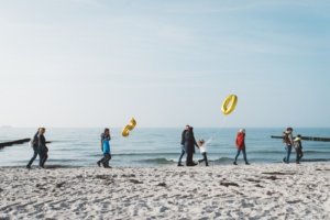 Familienshooting am Strand – Spaziergang zum 50. Jubiläum an der Ostsee Mehrere Generationen beim Familienshooting am Strand von Rostock: Die Familie spaziert gemeinsam mit goldenen Ballons in Form der Zahl 50 entlang der Ostseeküste – Symbol für eine goldene Hochzeit.